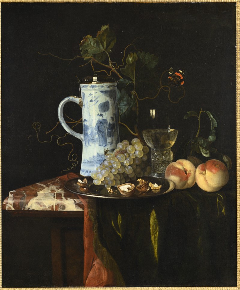 Stilleven met een kan van chinees porselein, druiven, walnoten, roemer, perziken en een kleed op een marmeren tafel